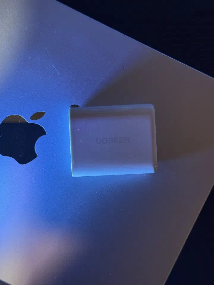 綠聯 CD275 65W 充電器放在 MacBook Air 機背旁的尺寸對比